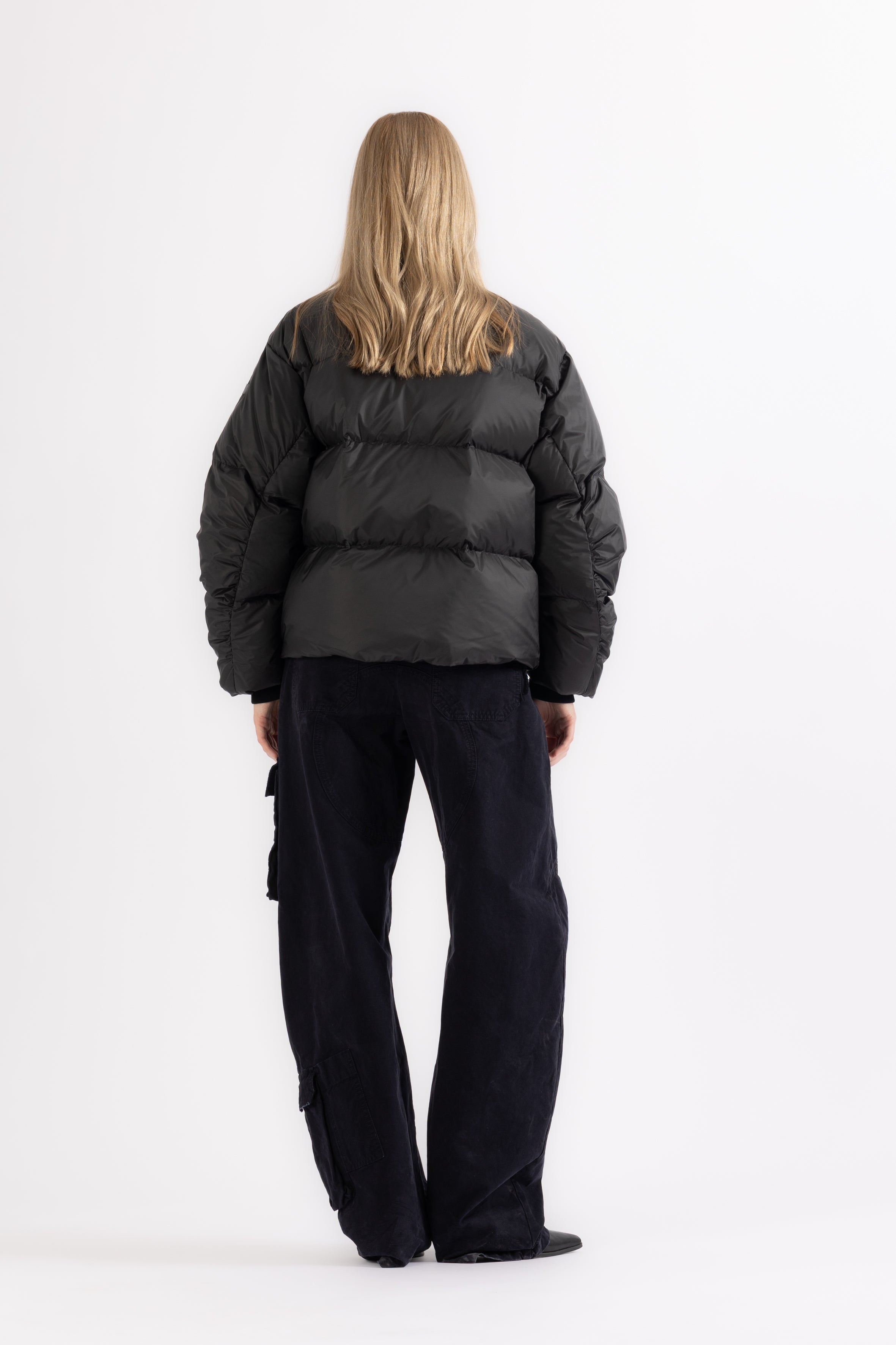 Person wearing a black LEMPELIUS puffer jacket and pants on a white background