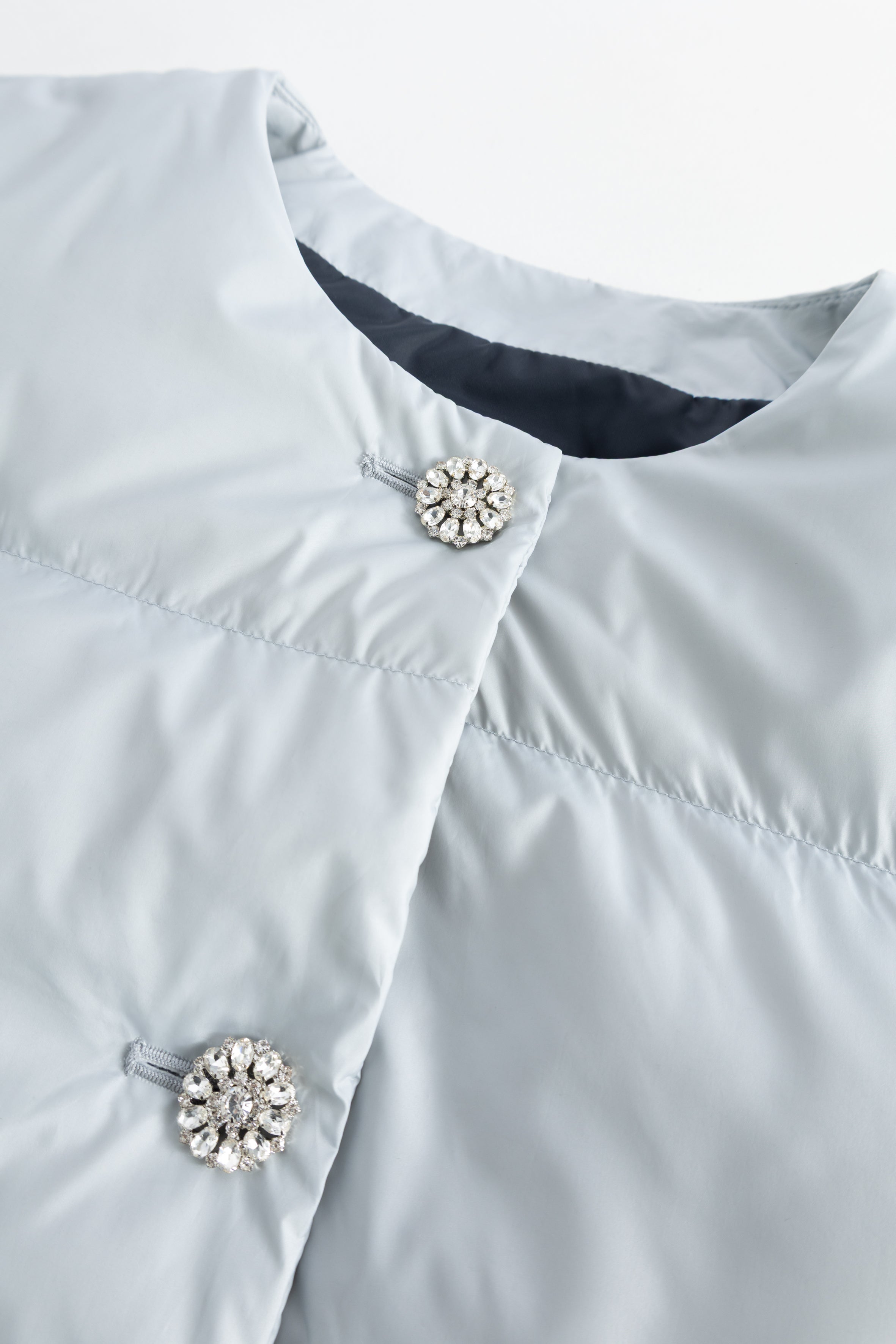 Light blue, light gray puffer jacket with rhinestone button closure