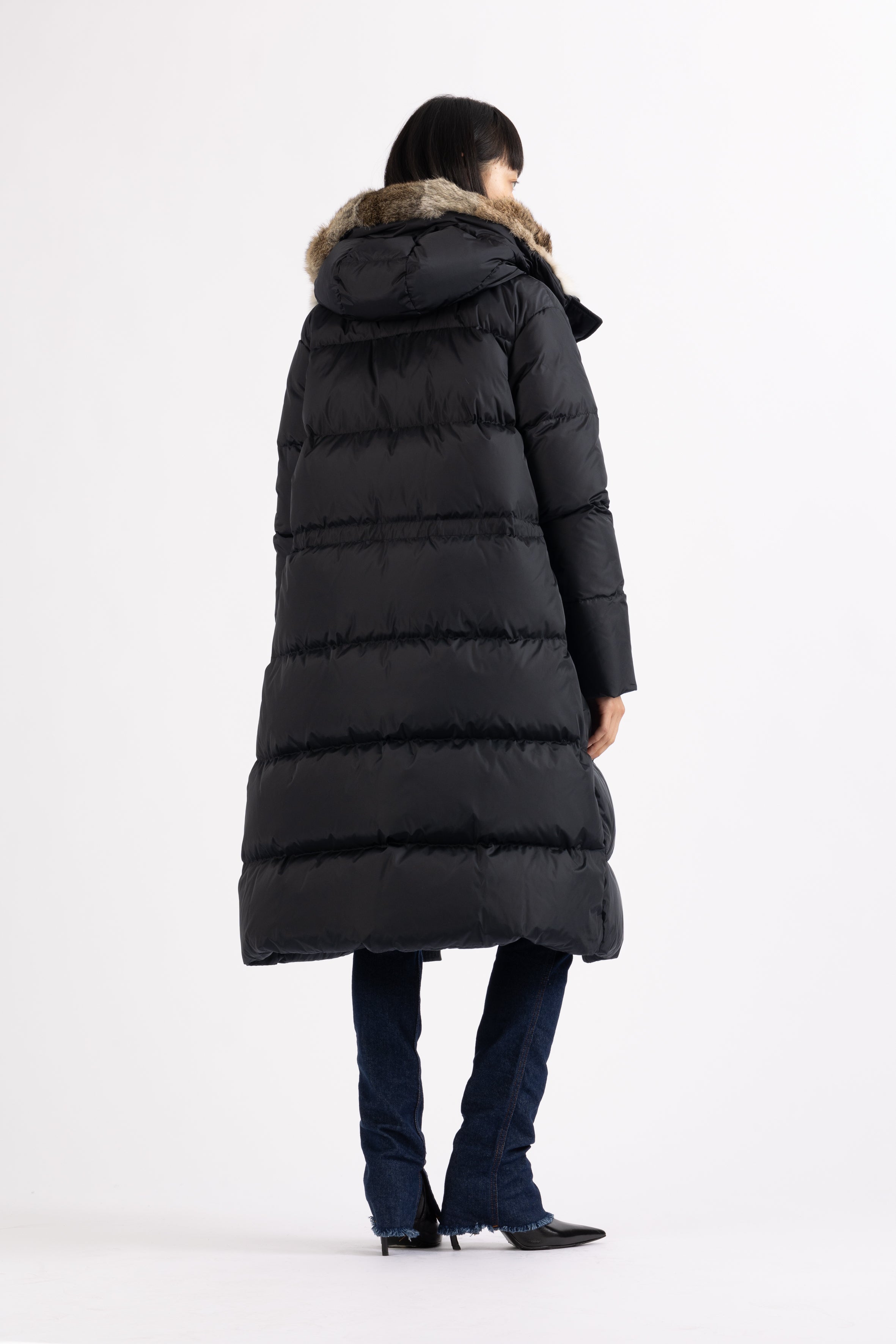 Long Lempelius Downcoat with a slim, slightly flared silhouette in dark blue
and hood with extra soft, removable rabbit fur