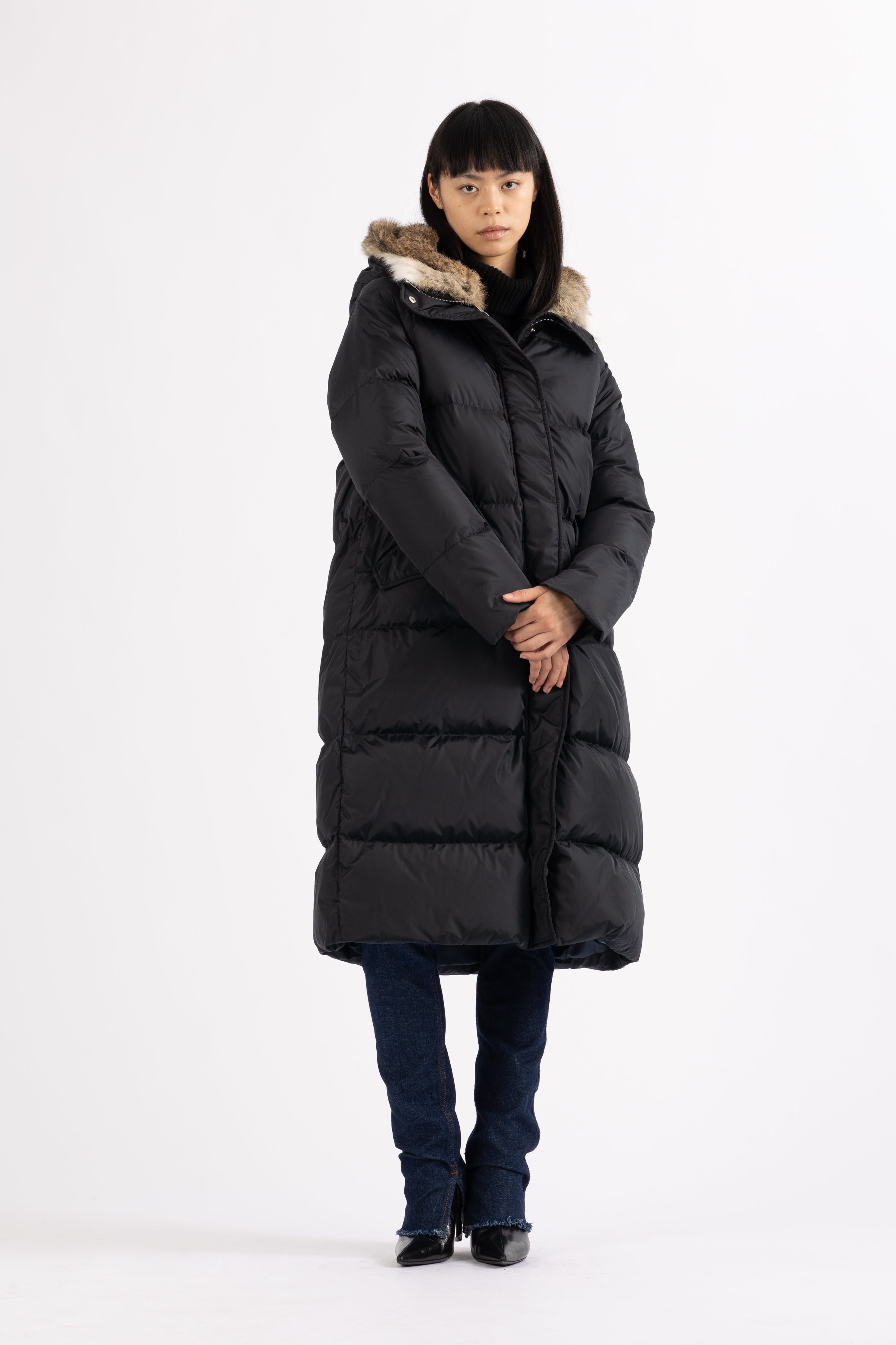 Long Lempelius Downcoat with a slim, slightly flared silhouette in dark blue
and hood with extra soft, removable rabbit fur