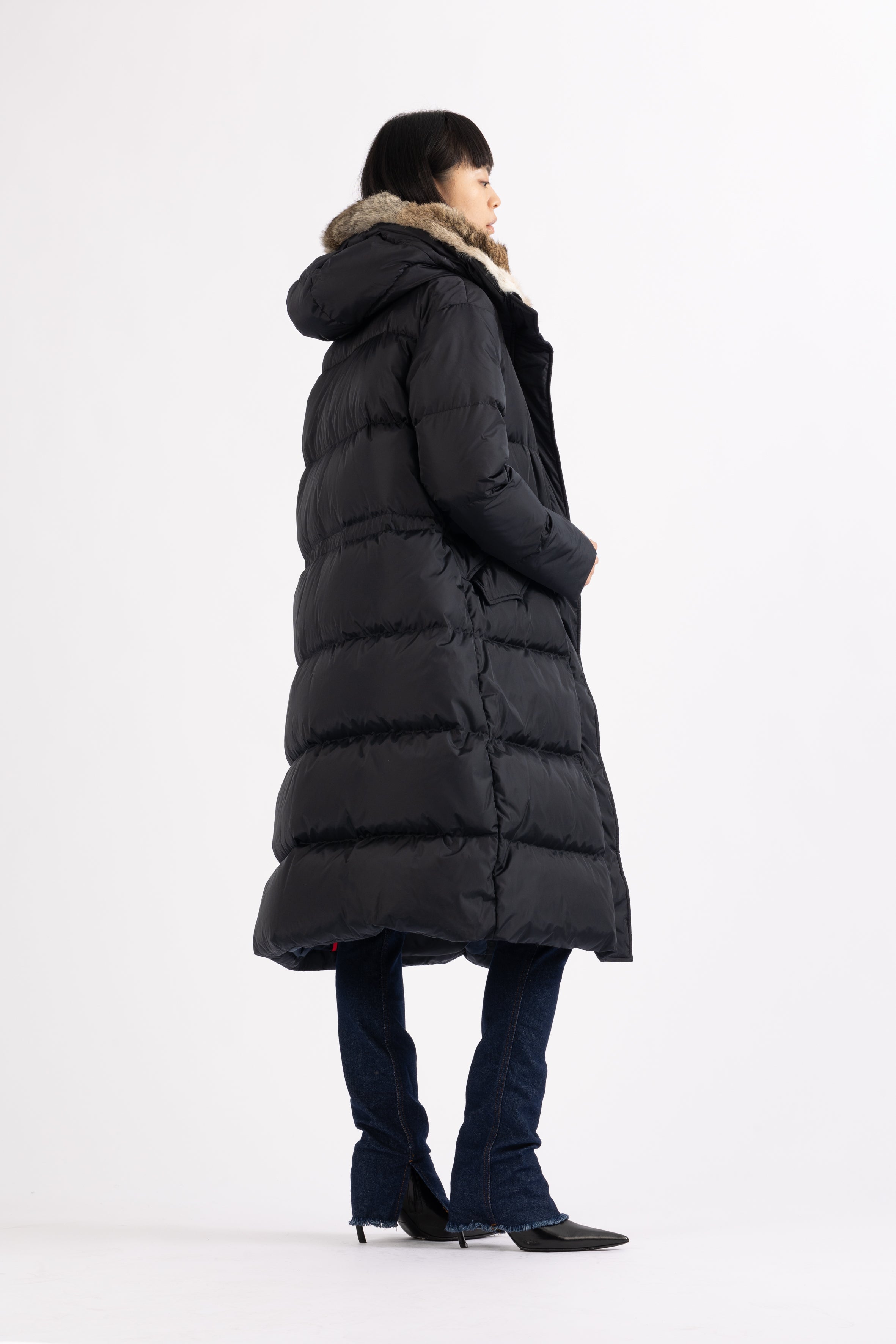 Long Lempelius Downcoat with a slim, slightly flared silhouette in dark blue
and hood with extra soft, removable rabbit fur