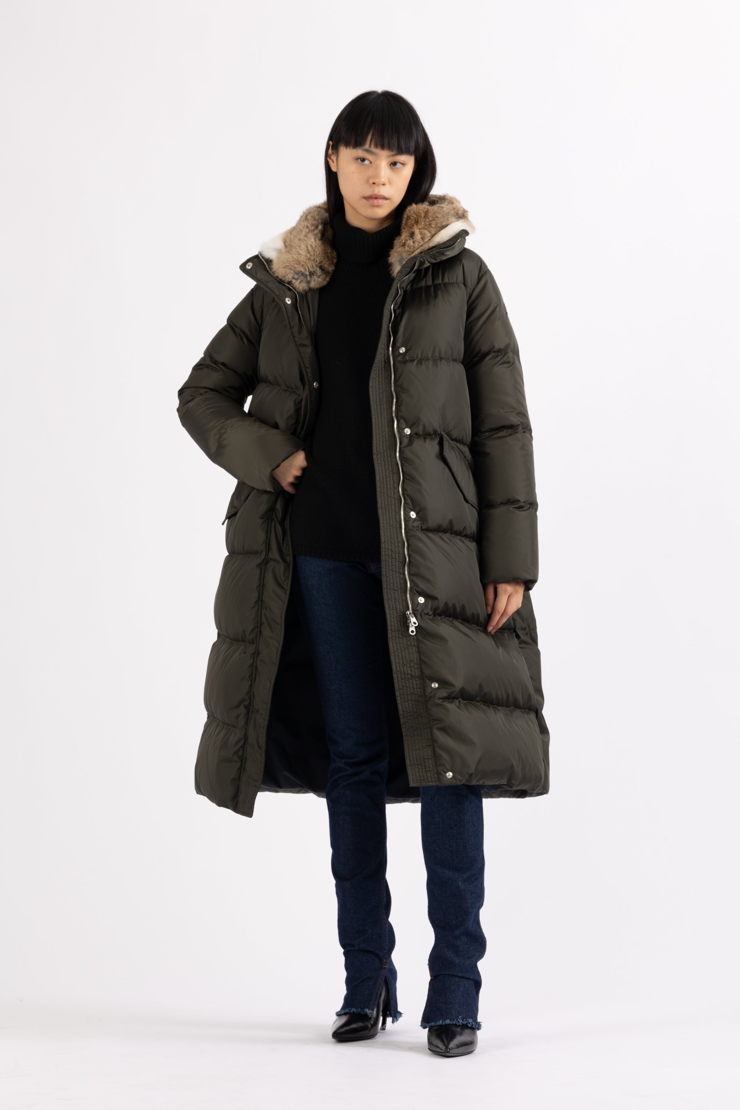 Long Lempelius Downcoat with a slim, slightly flared silhouette in dark green
and hood with extra soft, removable rabbit fur