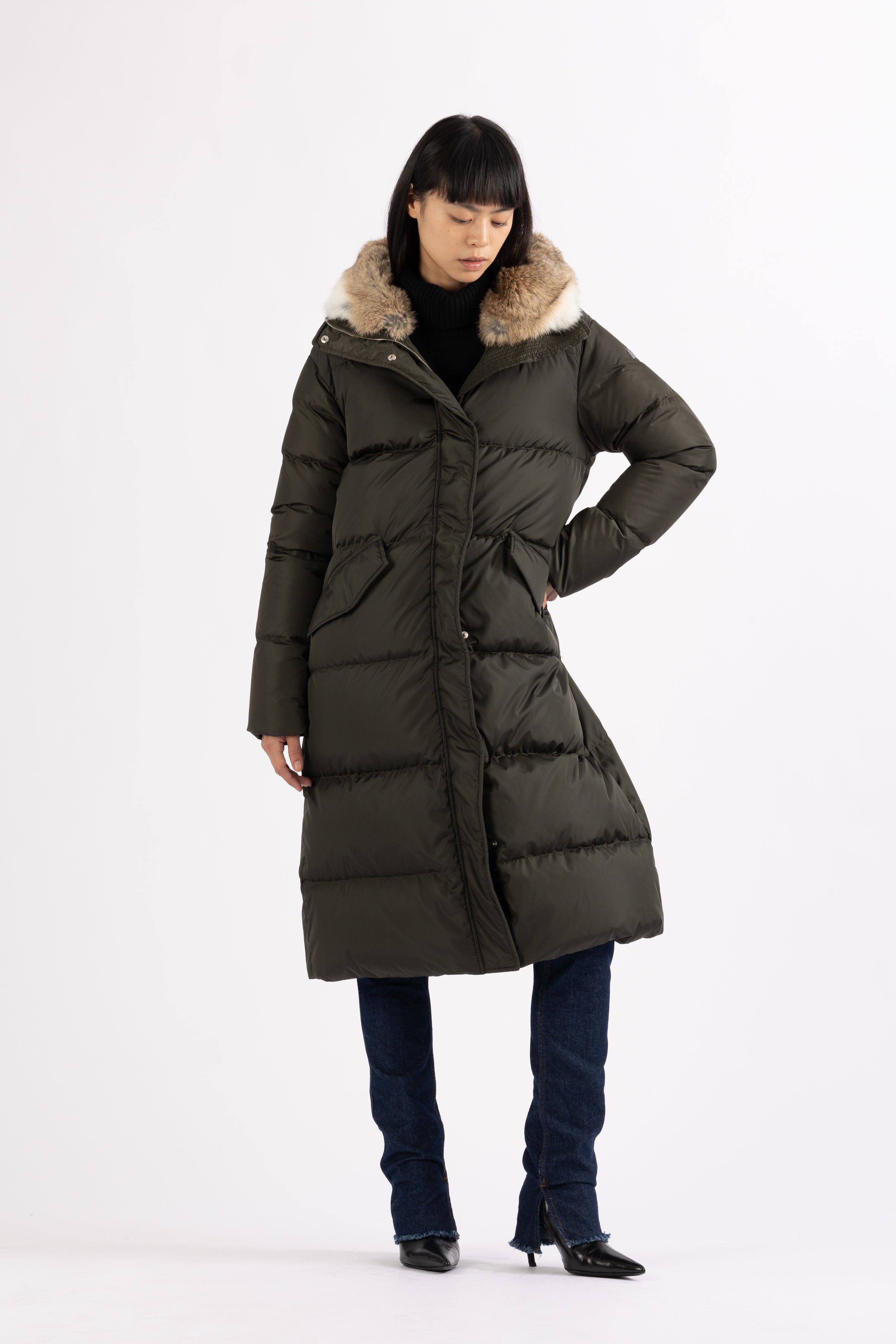 Long Lempelius Downcoat with a slim, slightly flared silhouette in dark green
and hood with extra soft, removable rabbit fur