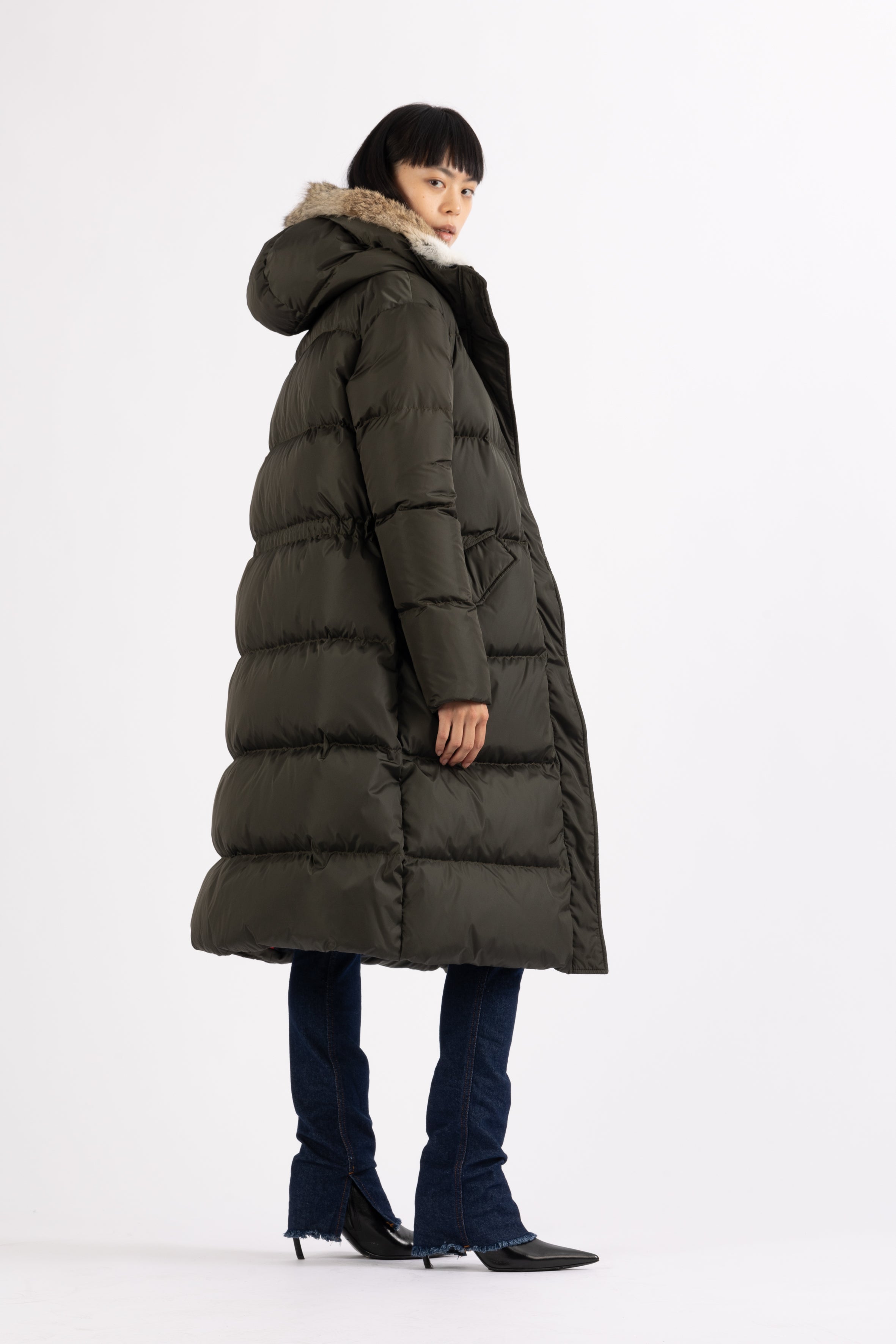 Long Lempelius Downcoat with a slim, slightly flared silhouette in dark green
and hood with extra soft, removable rabbit fur