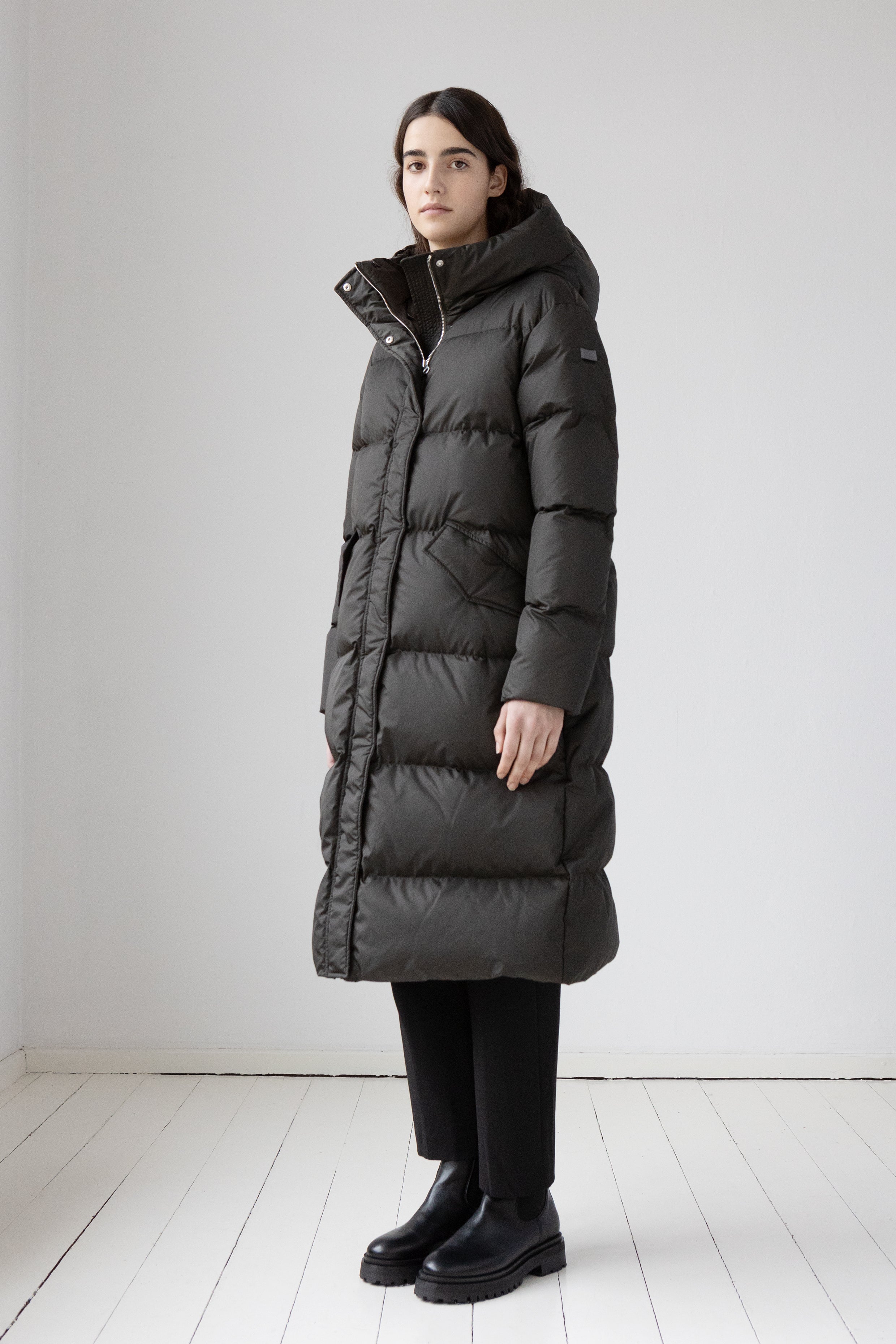 Long down coat in a dark color from the side